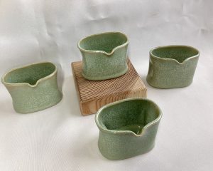 Four small vases with indents for holding